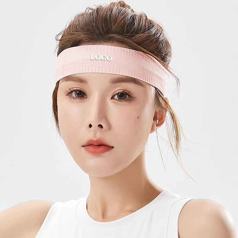 Front studio portrait of woman wearing slim light pink ribbed seamless sports headband with centered custom printed blank LOGO marking, ventilated fine rib stretch knit, sweat-wick non-slip band for yoga, gym and branded wholesale accessories.