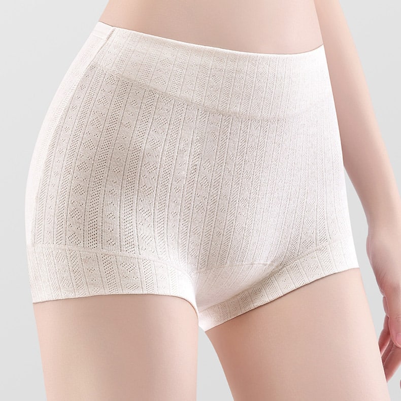 Close-up studio shot of womenโs off-white organic cotton boxer briefs, hollow vertical mesh jacquard knit, wide seamless non-roll waistband, breathable hypoallergenic natural cotton fabric, anti-chafe mid-thigh cut, moisture-absorbing eco intimates for daily wear, OEM sustainable private label underwear.