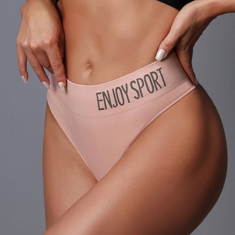Close-up studio shot of womenโs light pink private label seamless shapewear bikini brief, wide jacquard logo waistband printed with "ENJOY SPORT", smooth seamless stretch knit, medium compression hip shaping fit, CNC knitted moisture-wick fabric for sport and daily intimate wear, customizable branding from OEM factory.